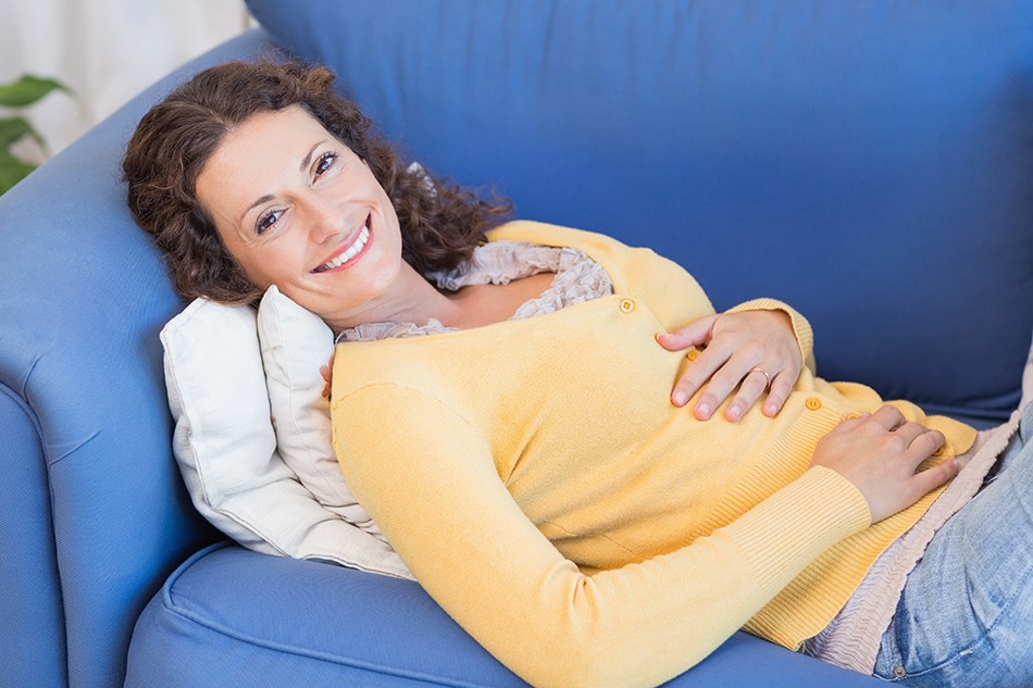 Woman on Couch with Stomachache Relief